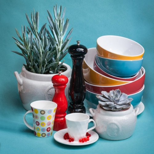 Colourful bowls, mugs and kitchen accessories with decorative plants