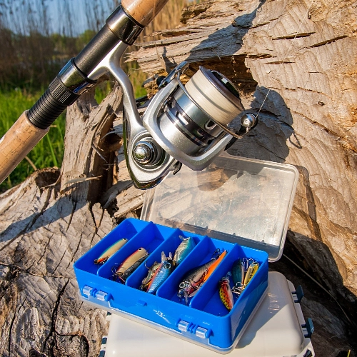 Fishing rod, reel and tackle box with lures outdoors