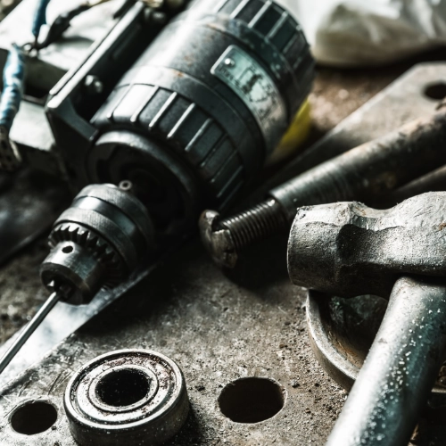 Drill, hammer and metal hardware tools on a workbench