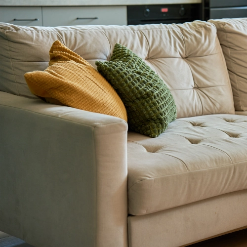 Cream fabric sofa with mustard yellow and green textured cushions