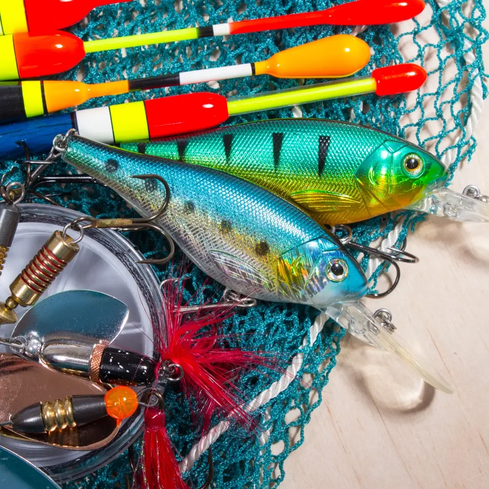 Colourful fishing lures, floats and line arranged on a fishing net.