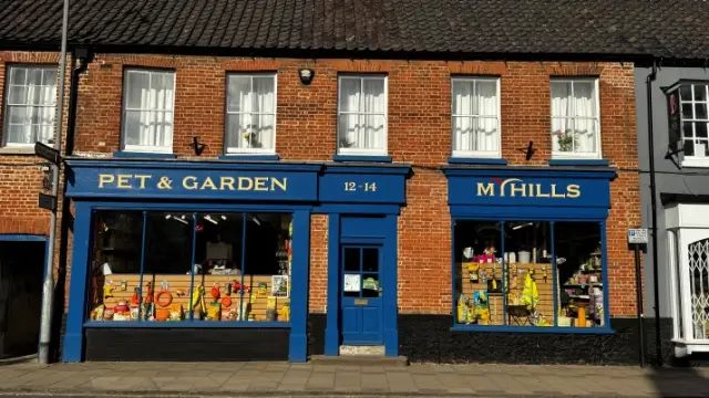 Myhills Pet & Garden shopfront in Swaffham with blue signage and pet and gardening products displayed in the windows.